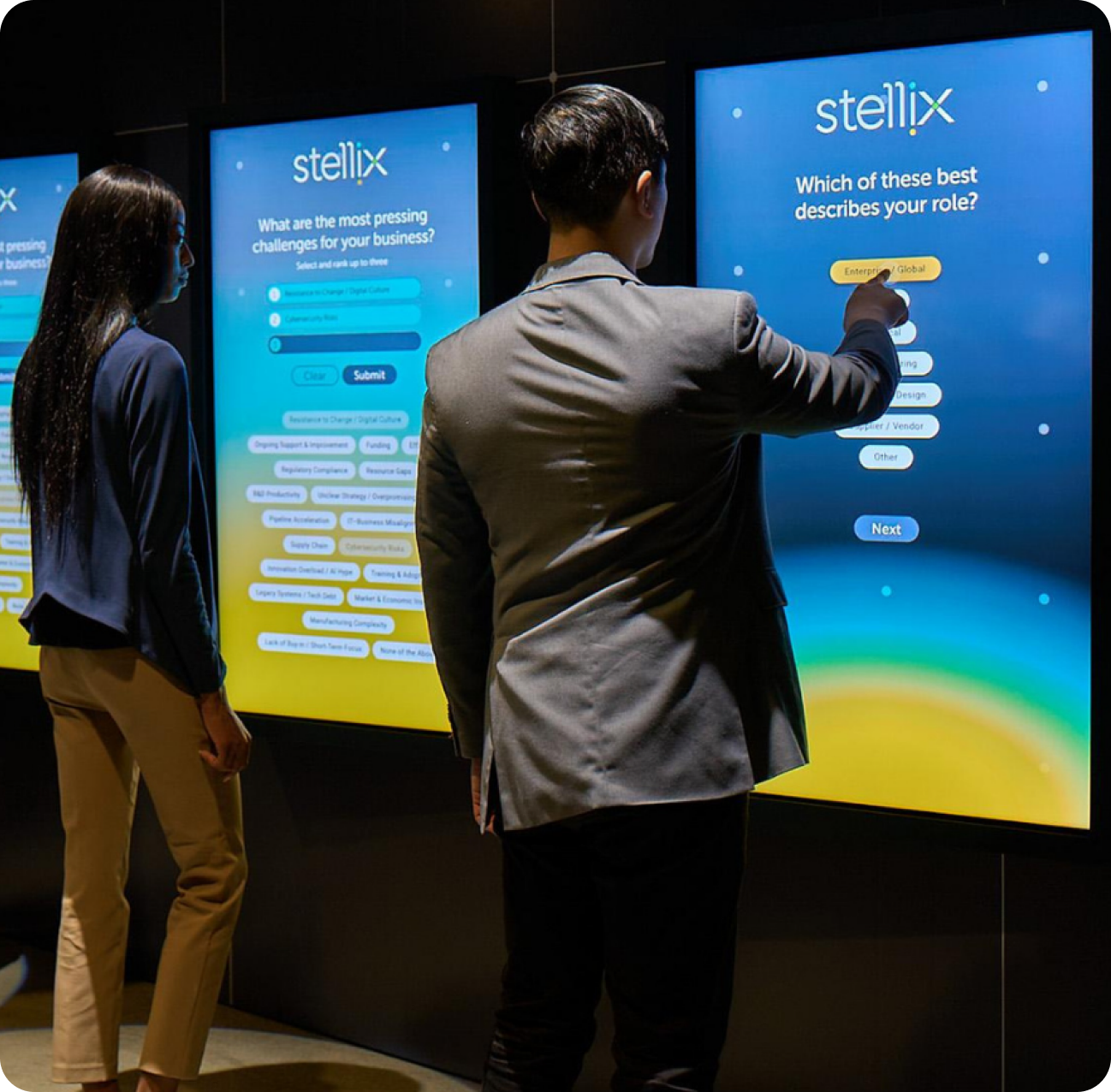Aspire attendees interacting with Stellix Experience Center touchscreen display