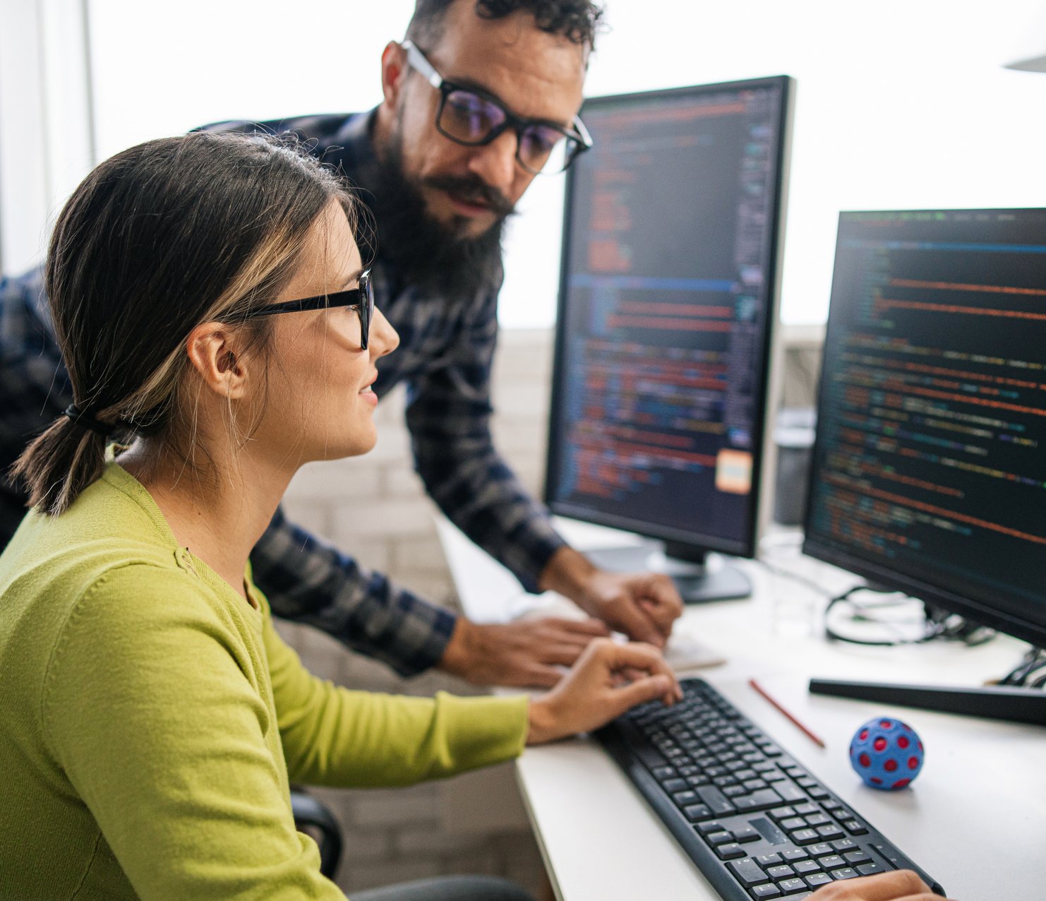 Stellix employees reviewing code on flatscreen